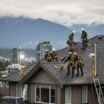Skilled roofing team installing new asphalt shingles on a modern Vancouver residential home, emphasizing safety gear and local expertise under overcast skies.