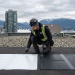 Professional photograph comparing TPO and EPDM flat roofing membranes on a Vancouver commercial building with a roofer performing an inspection