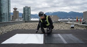 Professional photograph comparing TPO and EPDM flat roofing membranes on a Vancouver commercial building with a roofer performing an inspection